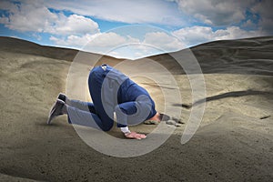 The businessman hiding his head in sand escaping from problems