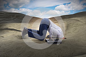 The businessman hiding his head in sand escaping from problems