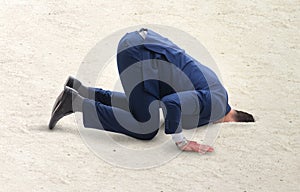 Businessman hiding his head in sand escaping from problems