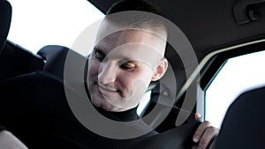 Businessman in his car fastening the seatbelt, safe driving concept