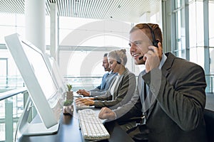 Businessman with his colleagues talking on headset at desk