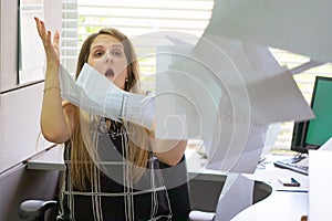 Businessman at his desk throws documents and papers into the air