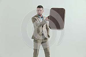 Businessman in his forties holding luggage up and leaving town