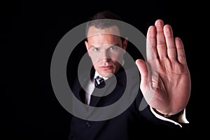 Businessman with his hand raised in signal to stop