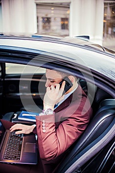 Businessman in his limo car with lap top