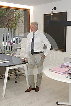 businessman in his office standing and looking a way