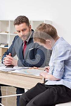 Businessman with his son drawing on business papers