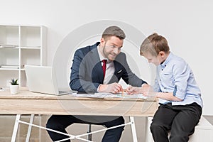 Businessman with his son drawing on business papers