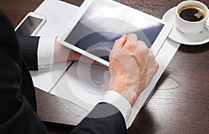 Businessman at his workplace with a Cup of coffee and tablet computer. Close-up