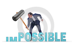 Businessman hitting the word impossible with hammer