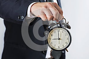 Businessman hold alarm clock. Business time management concept. Businessman with alarm clock in hand