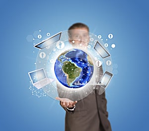 Businessman hold Earth with electronics, graphs