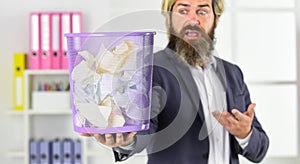 businessman hold full paper bin with crumpled papers. business and trash. man search crimpled paper in basket. ceo in