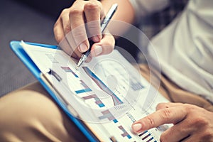 Businessman hold pen and working calculate data. document graph chart and report marketing. Business office concept