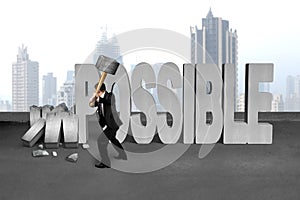 businessman hold sledgehammer to smash impossible 3D concrete word