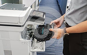 Businessman hold toner cartridge to put into printer feed