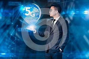 The businessman holding the 5G hologram and element of this image furnished by Nasa. The concept of 5G, communication, technology