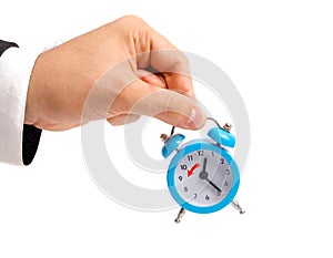 A businessman is holding an alarm clock. Transition to winter time, transfer of hours to an hour back. Watch in hand. The concept