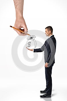 Businessman holding bag of money with big hand that draws it