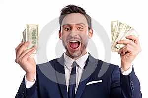 Businessman is holding a big stack of dollars and smiles isolated on a white background