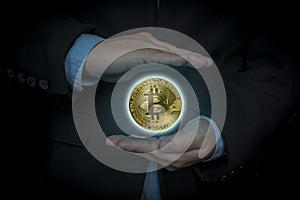 Businessman holding bitcoin gold coin in dark background. Virtual cryptocurrency concept. digital currency coin