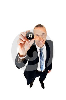 Businessman holding black billiard ball