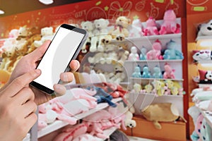 Businessman holding blank screen for text on smartphone, mobile, cell phone with blurry toy shelf