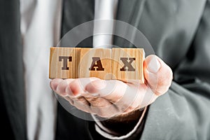 Businessman Holding Blocks with TAX Word