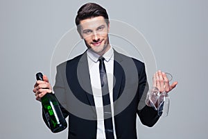 Businessman holding bottle with champagne and glass