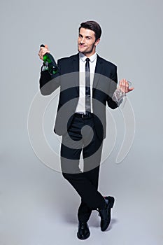 Businessman holding bottle with champagne and glass