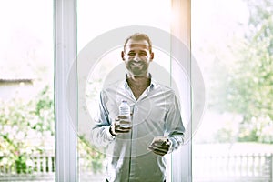 Businessman holding bottle of water and smartphone