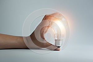 Businessman holding a bright light bulb in his hand, for concept of presenting new idea
