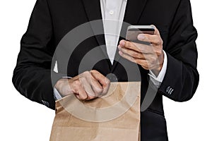 Businessman holding brown paper bag, and using smart phone, isolated on white background