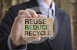 Businessman holding businesscard message recycle, reduce, reuse.