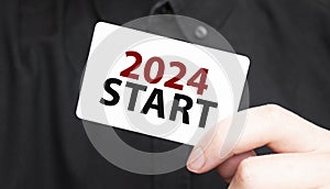 Businessman holding a card with text 2024 START, business concept