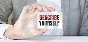 Businessman holding a card with text DESCRIBE YOURSELF