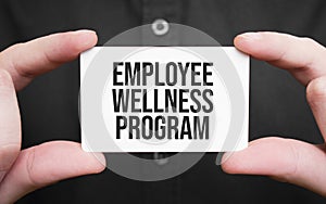 Businessman holding a card with text Employee Wellness program,business concept