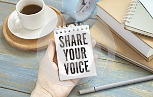 businessman holding a card with text SHARE YOUR VOICE, business concept image with soft focus background and vintage