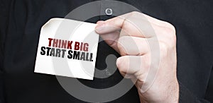 Businessman holding a card with text THINK BIG START SMALL, business concept