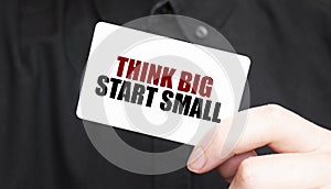 Businessman holding a card with text THINK BIG START SMALL, business concept