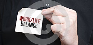 Businessman holding a card with text work life balance,business concept