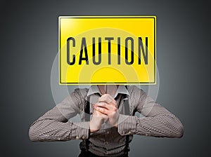 Businessman holding a caution sign