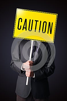 Businessman holding a caution sign