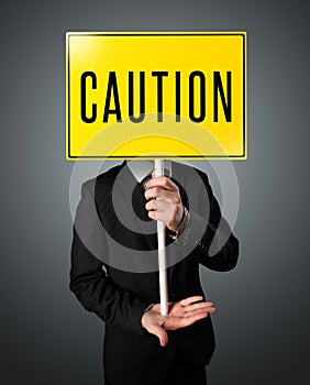 Businessman holding a caution sign