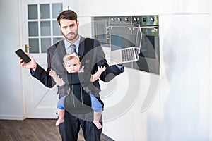 Businessman holding cellphone and laptop while carrying daughter