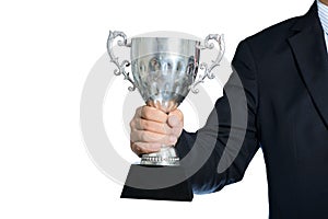 Businessman holding a champion silver trophy on white background