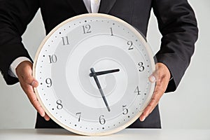 Businessman holding a clock ready to work  Strategy and time management in the office,  Concept: symbol manage at deadline profess