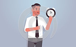 Businessman holding clock time management deadline concept business man with alarm clock horizontal portrait