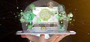 Businessman holding a Cloud of green ecology icon bubble with a laptop 3d rendering