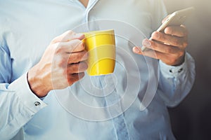 Businessman holding coffee and smartphone